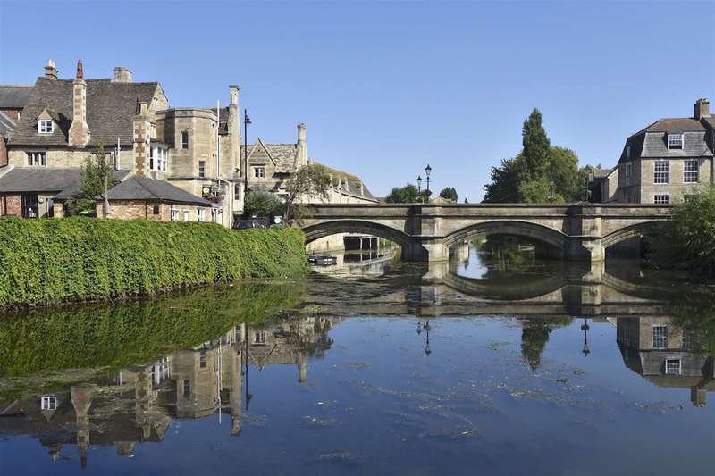 The idyllic view along the river of the Bridge over the  Welland in Stamford, UK, on a clear blue sky summer day